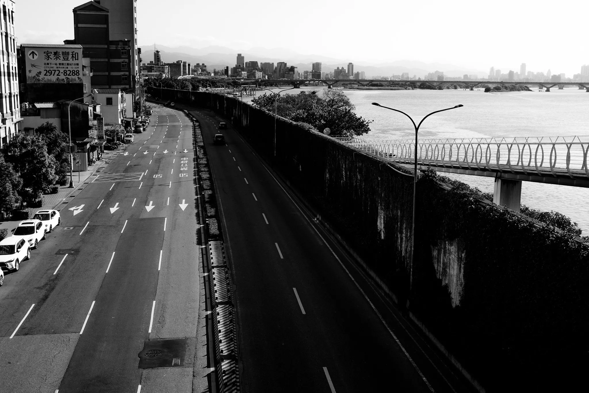河岸道路旁從高處望向橋梁、城市天際線與遠方山影，365 Project October 4