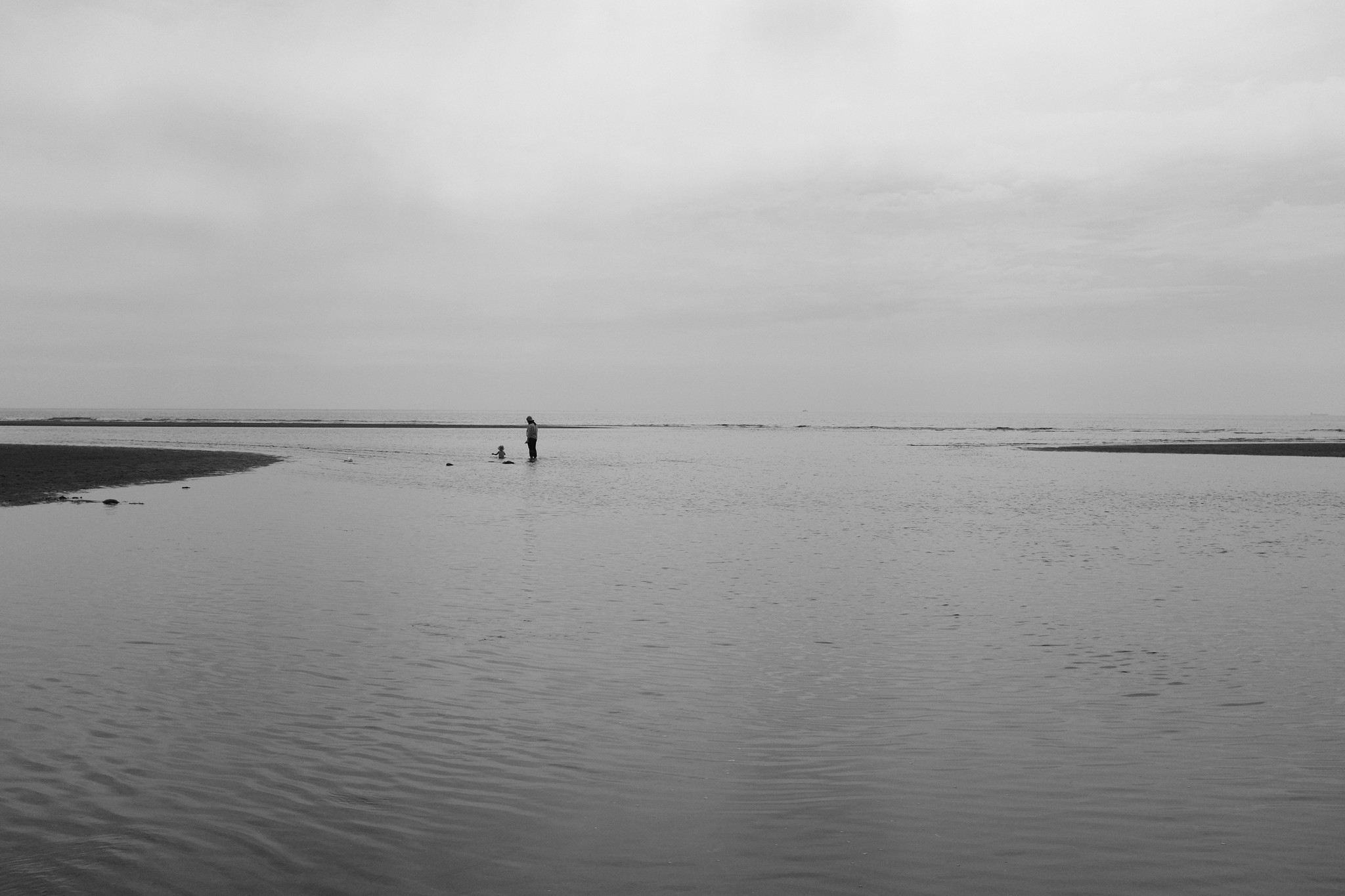 Black and white coastal lighthouse and umbrella figure - INTERTIDAL project cover