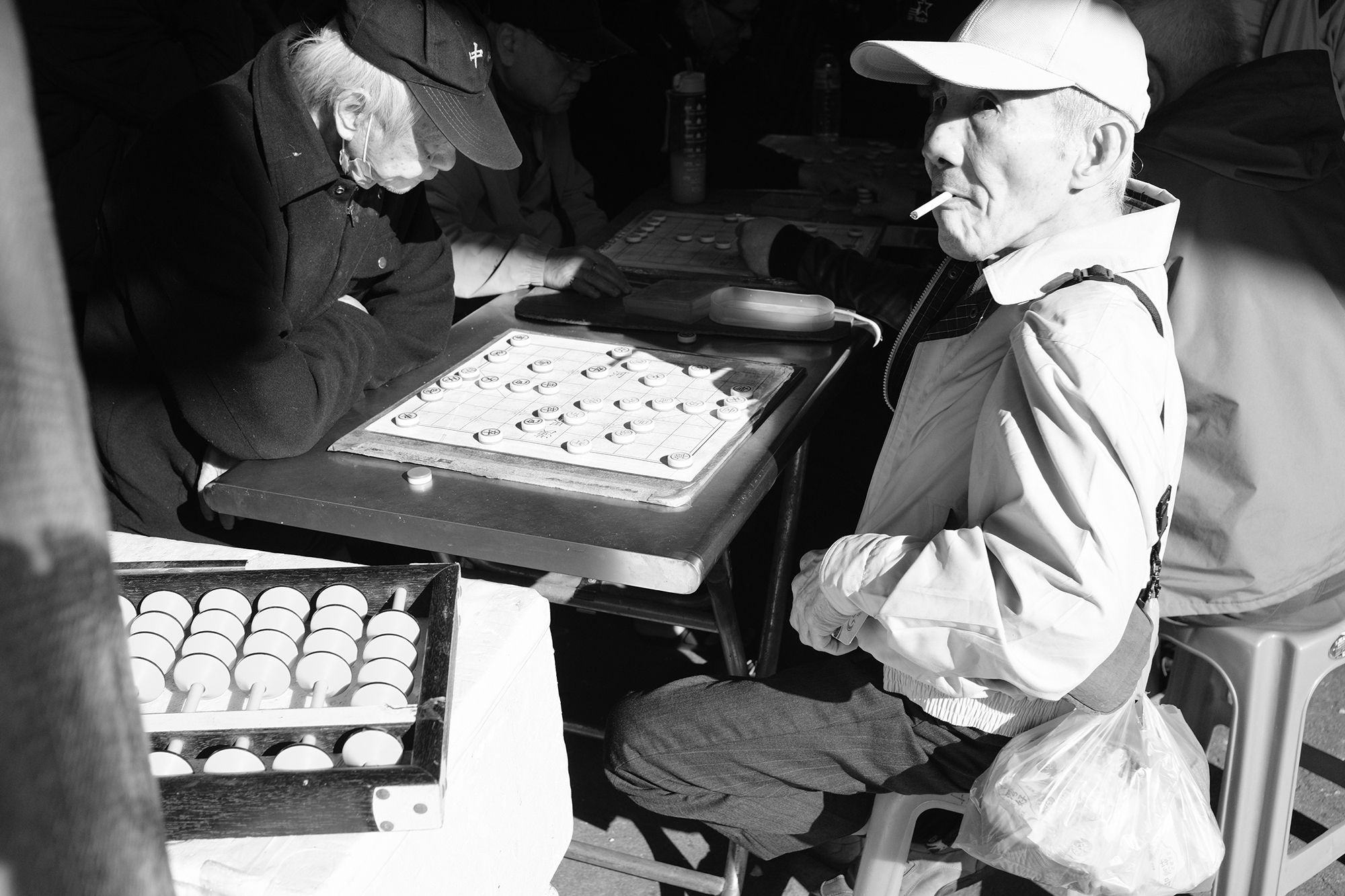 Black and white street photograph of elderly men playing Chinese chess in Keelung, Taiwan